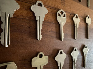 Close-up of various metal keys arranged in rows on a wooden surface, perfect for a New Jersey locksmith shop near me.